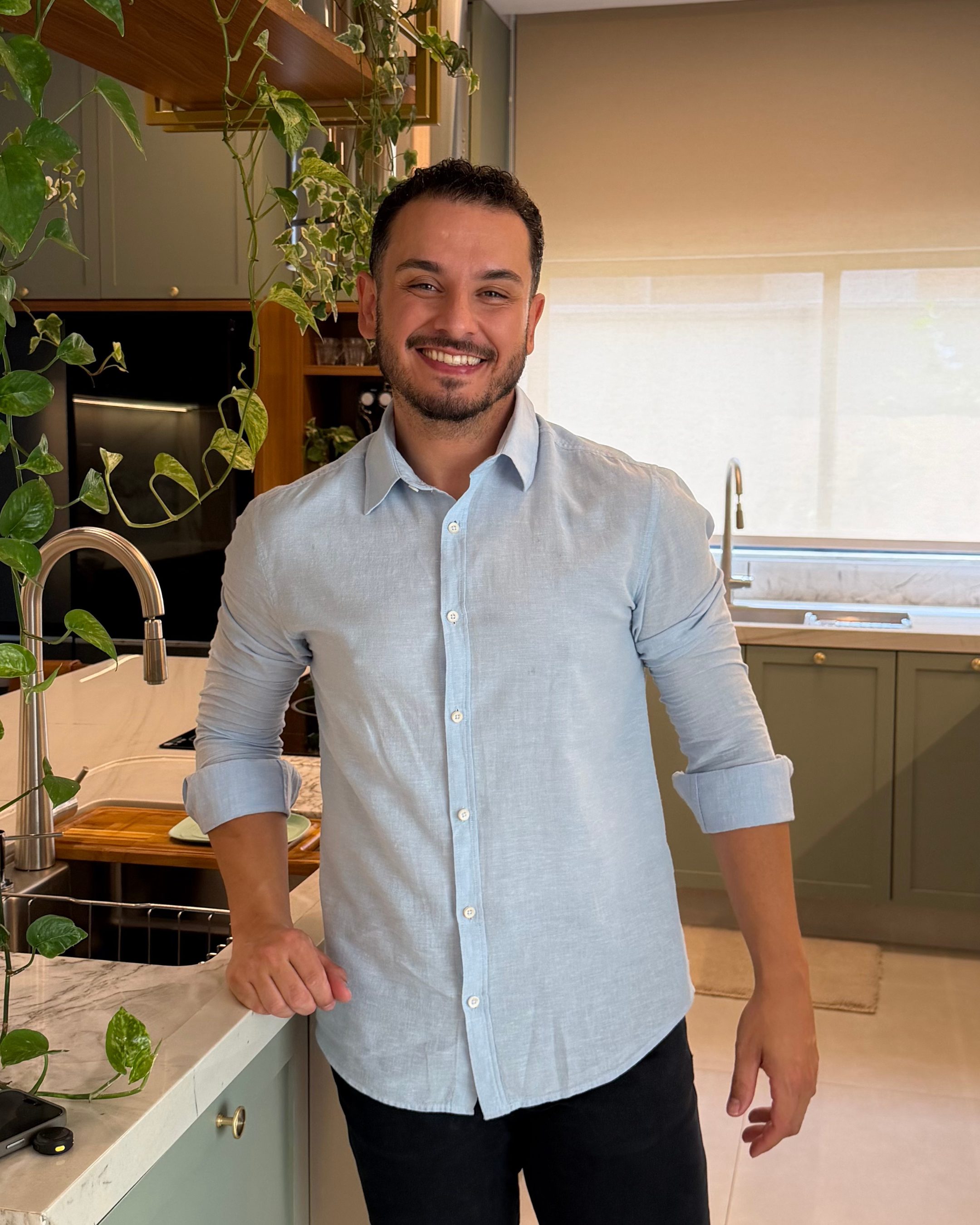 João Paulo Fragas, fundador da Casa Fragas Interiores, sorrindo em uma cozinha