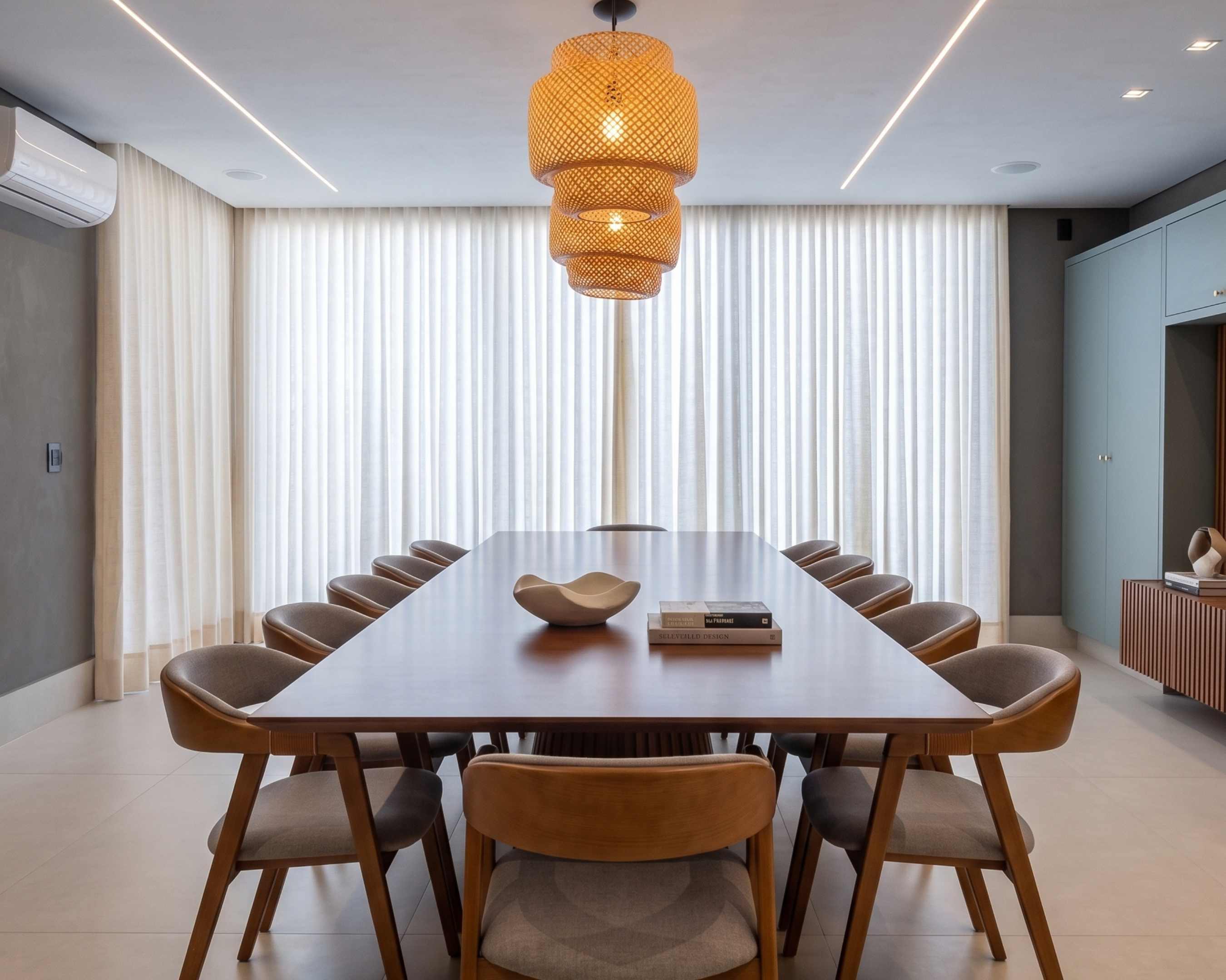 Sala de jantar com cortinas de tecido controlando a luz natural